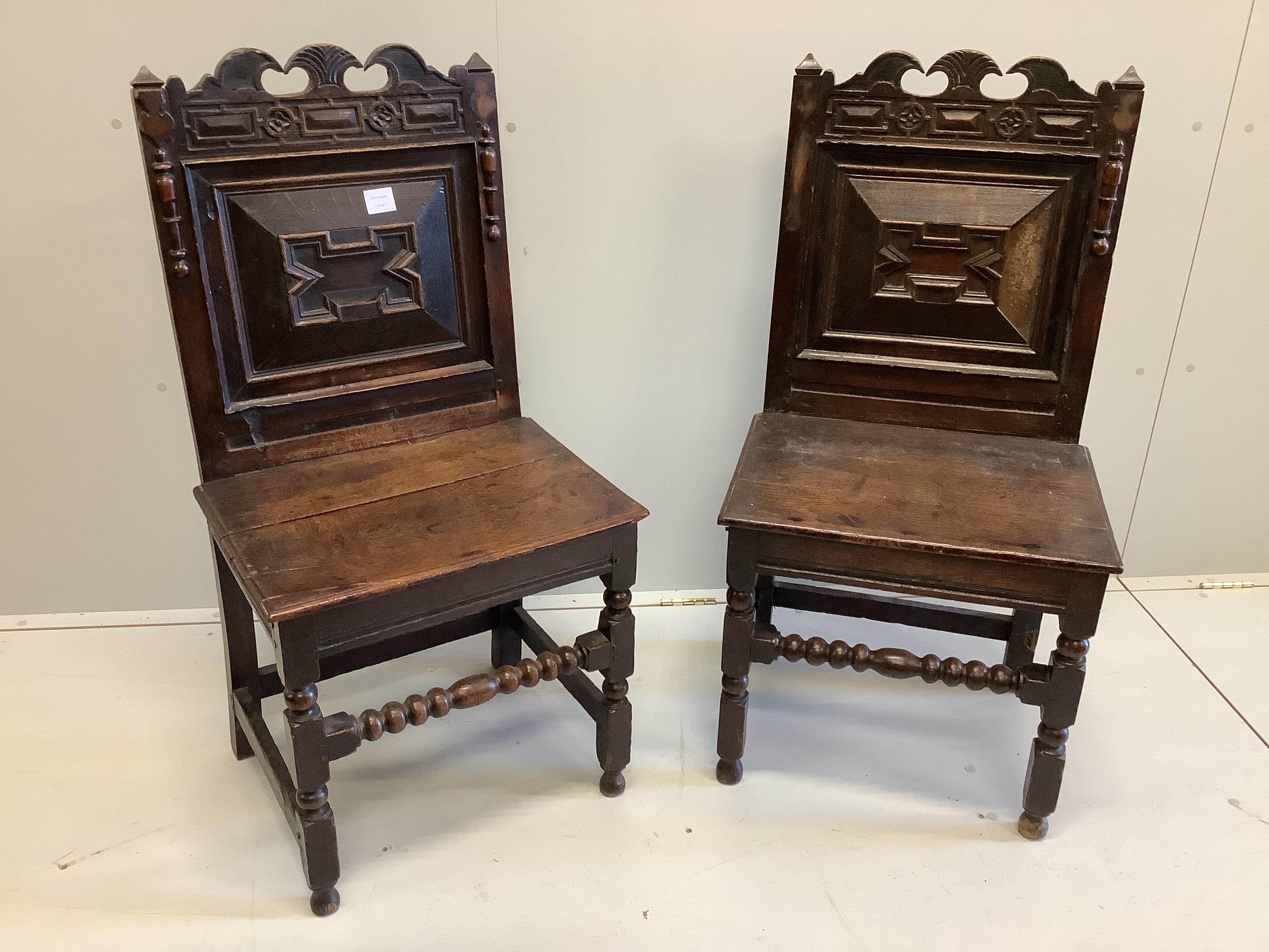 A pair of late 17th century oak wood seat chairs with moulded panelled backs, width 51cm, depth 42cm, height 101cm (one a.f.)